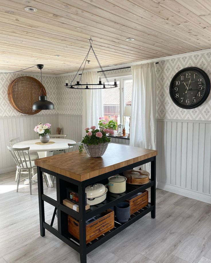 a kitchen island in the middle of a room with white walls and wood flooring