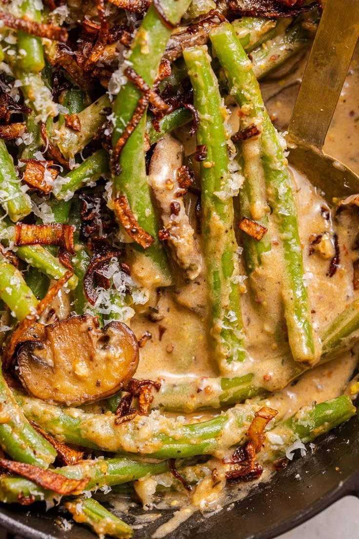 a skillet filled with green beans covered in sauce