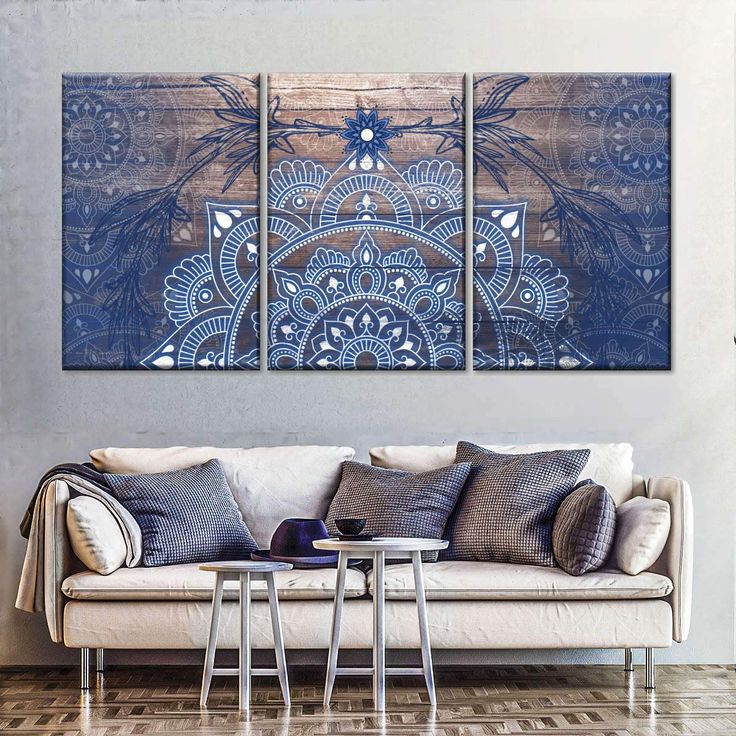 three pieces of artwork on a wall in a living room with couches and coffee table