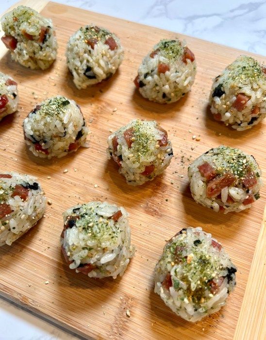 a wooden cutting board topped with lots of different types of appetizers on top of it