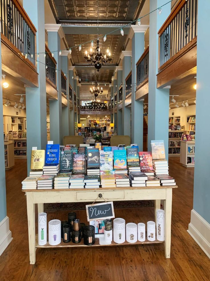 there is a table with books on it in the middle of an open floor plan