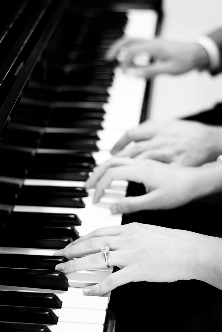 two people are playing the piano with their hands on top of each other's keys