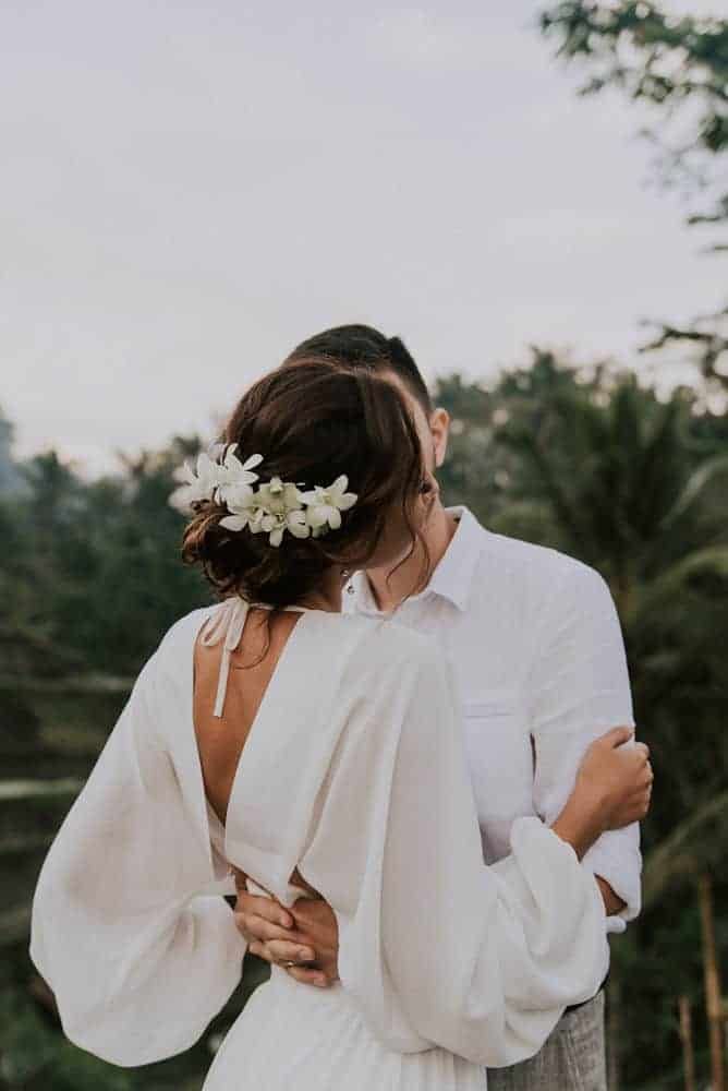 a man and woman standing next to each other with flowers in their hair on their foreheads