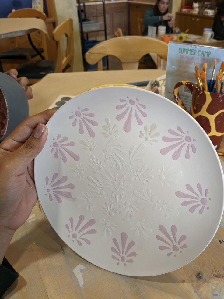 a person is holding a plate on a table