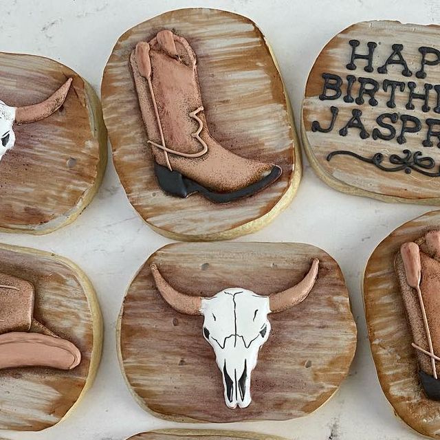 six decorated cookies with cow skulls and western themed decorations on wooden trays that say happy birthday jaspe