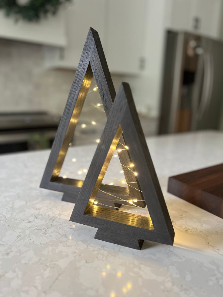 two wooden christmas trees sitting on top of a counter