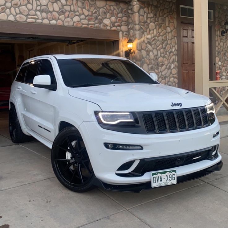 a white jeep parked in front of a house