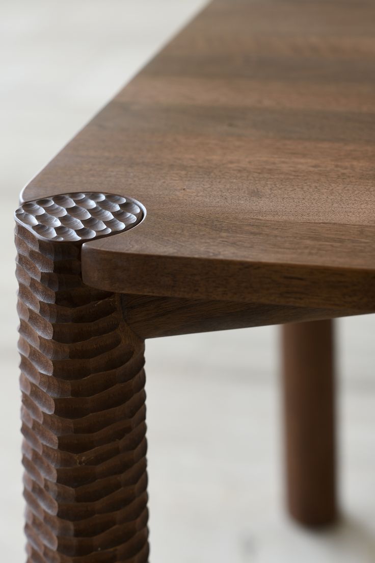 a close up of a wooden table with a metal object on it's edge