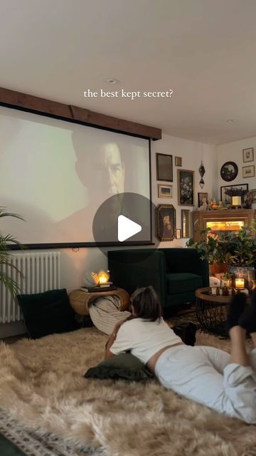 two people laying on the floor in front of a projector screen, watching tv