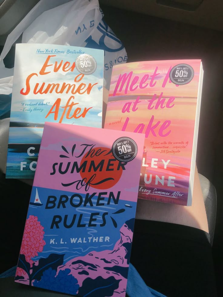 three books sitting in the back seat of a car, one is pink and one is blue