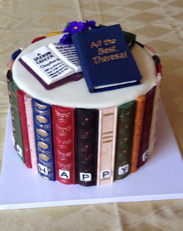 a cake made to look like a book with books on top and flowers in the middle