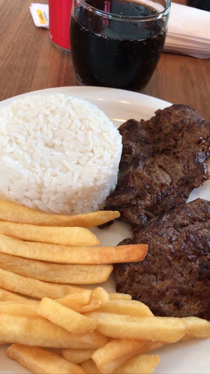 steak, rice and french fries on a white plate