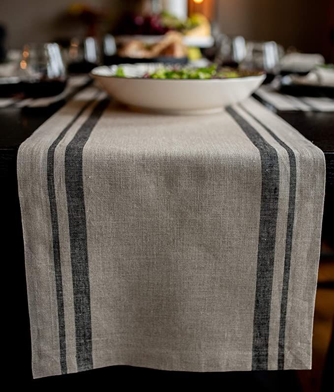 a bowl of food is sitting on a table with black and white striped linens