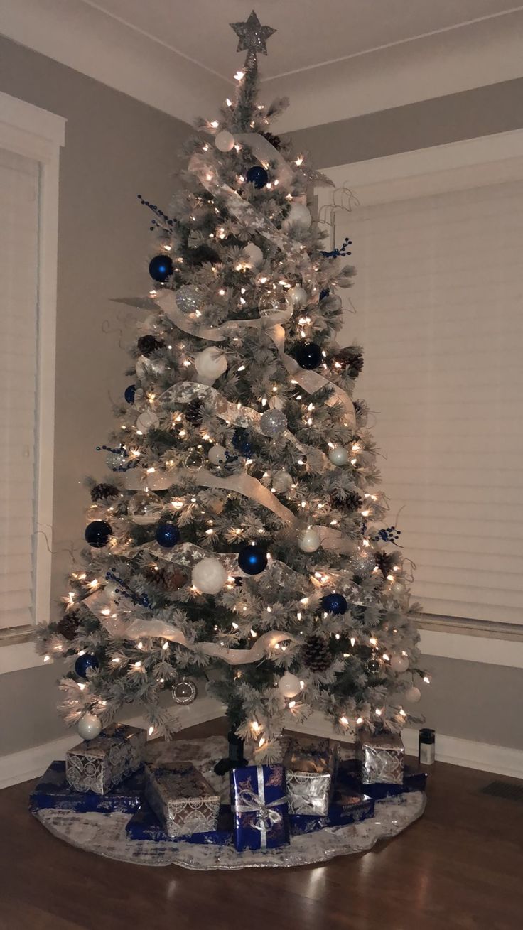 a white christmas tree with blue and silver ornaments