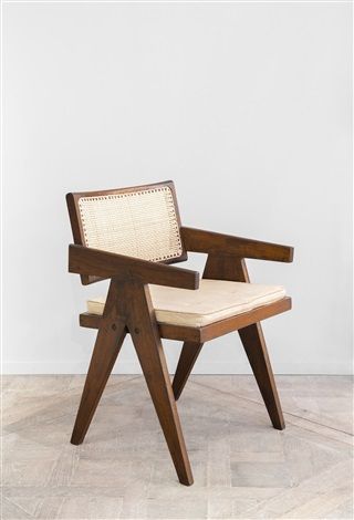 a wooden chair sitting on top of a hard wood floor next to a white wall