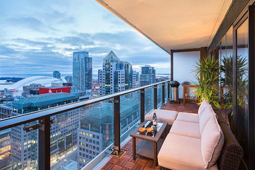 a balcony with couches and tables overlooking the city