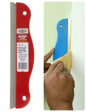 a hand holding a blue and red knife next to a white wall with a sticker on it