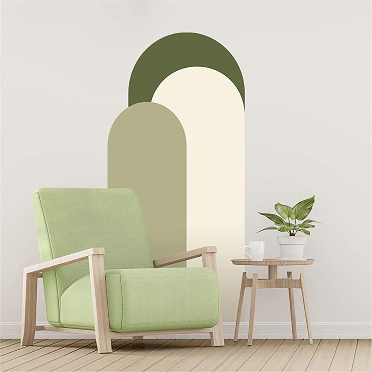 a green chair sitting in front of a wall with an oval painting on it's side