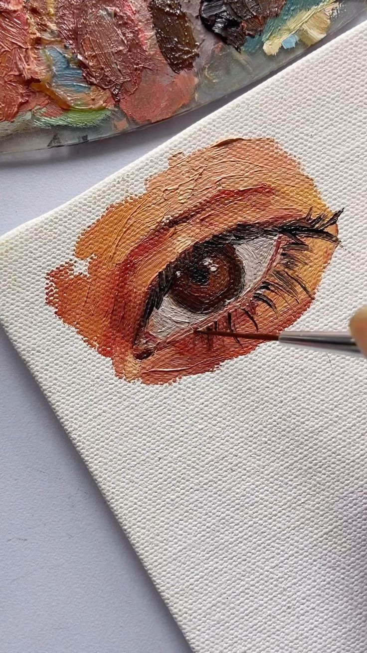 someone is painting an eye with acrylic paint on the canvas and it's brush