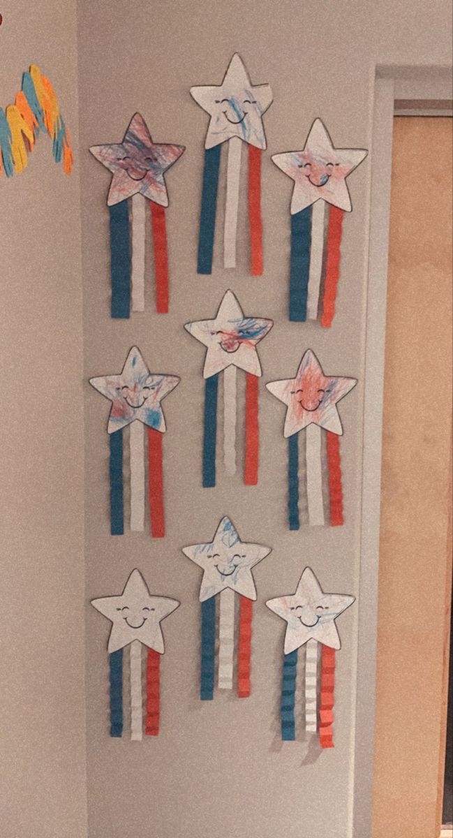 a bathroom decorated in patriotic colors with stars on the wall and paper streamers hanging from the ceiling