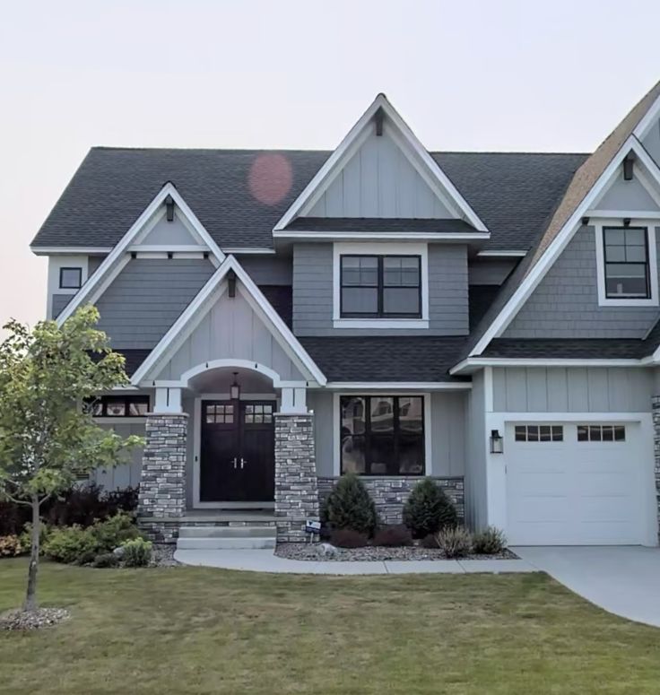 a large gray house with two garages on each side