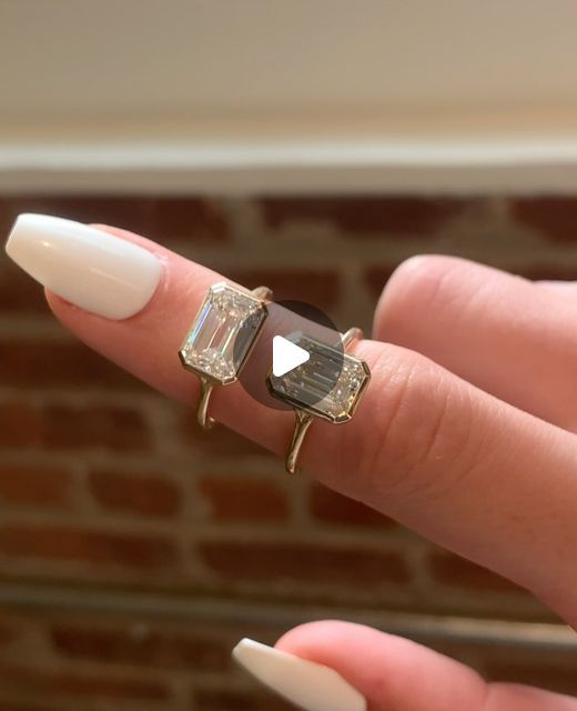 a woman's hand with two rings on it and one ring has a diamond in the middle