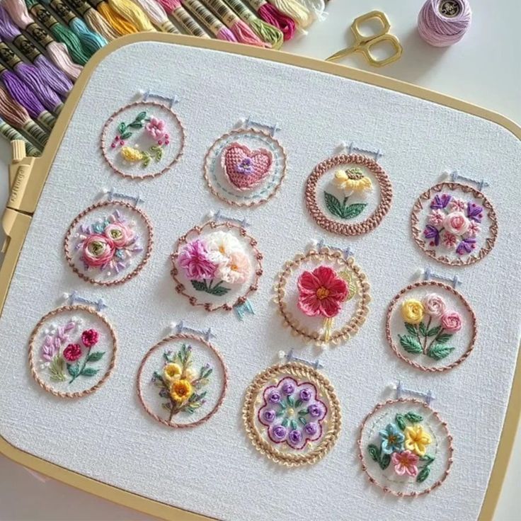 a table topped with lots of different types of embroidery