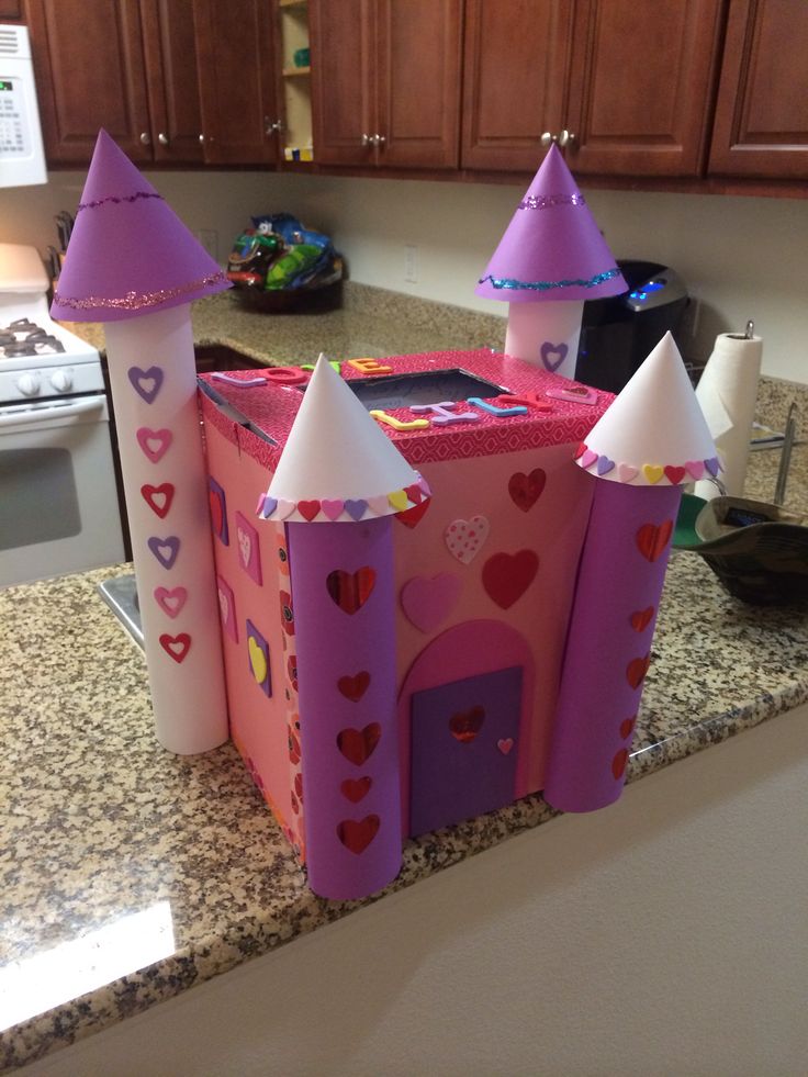 a pink castle made out of cardboard sitting on top of a kitchen counter next to a sink