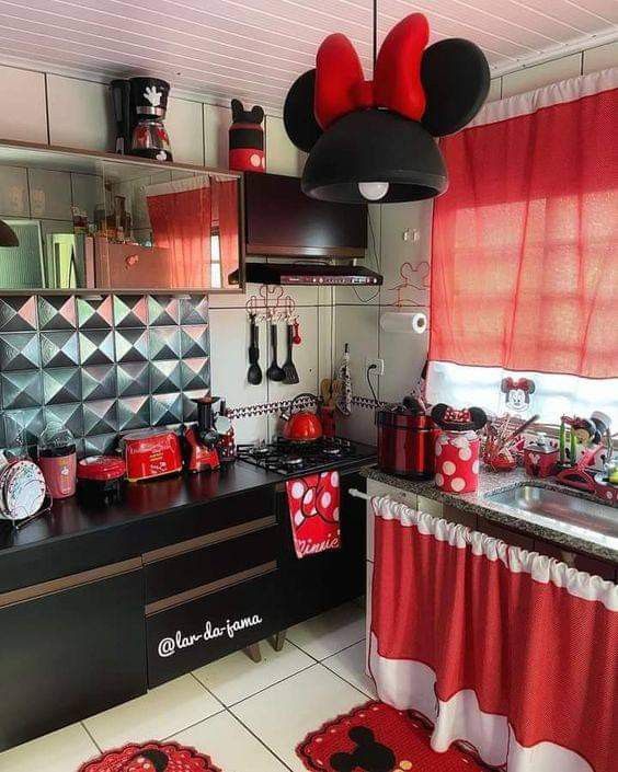 a kitchen with mickey mouse decorations and red curtains