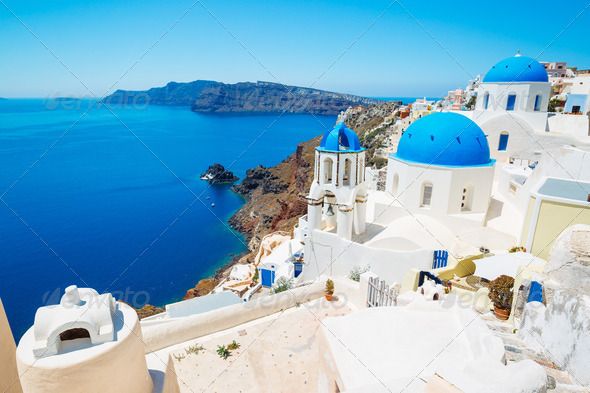 the blue domed buildings are overlooking the water and cliffs in oiai, greece