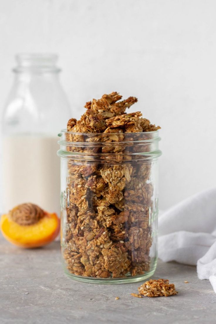 an image of granola in a glass jar with the title text overlay reads easy vegan gluten - free almond butter granola