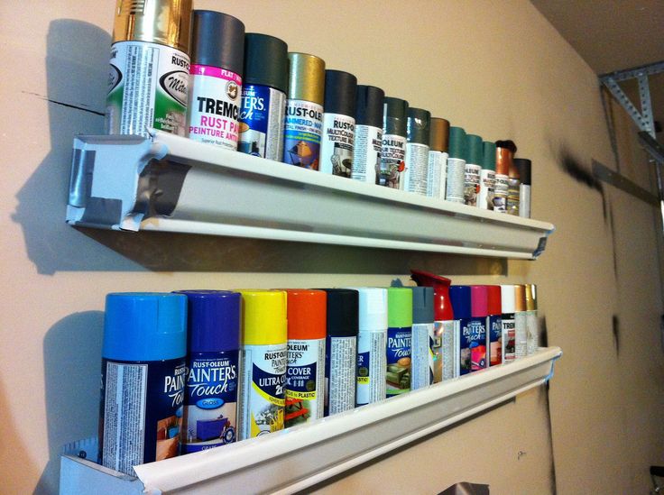 two white shelves filled with different types of spray paint