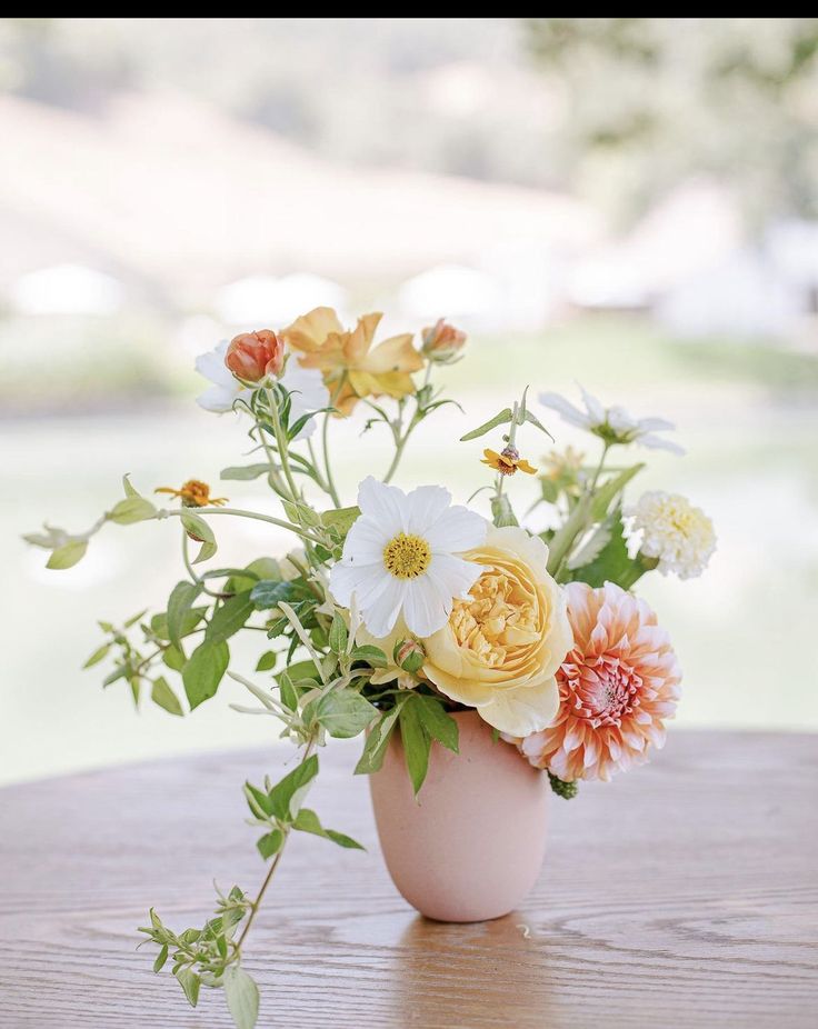 an arrangement of flowers in a vase on a table