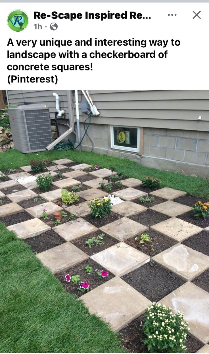 a checkerboard design in front of a house with grass and flowers on the ground