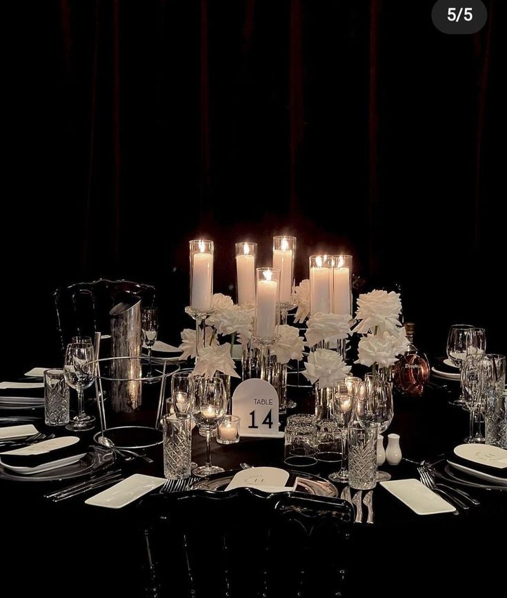 the table is set with white flowers and candles for an elegant dinner or special event