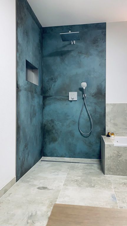 a bathroom with blue walls and a shower head