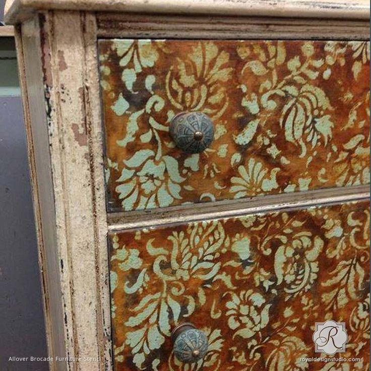 an old dresser has been painted with gold and orange floral designs on it's drawers