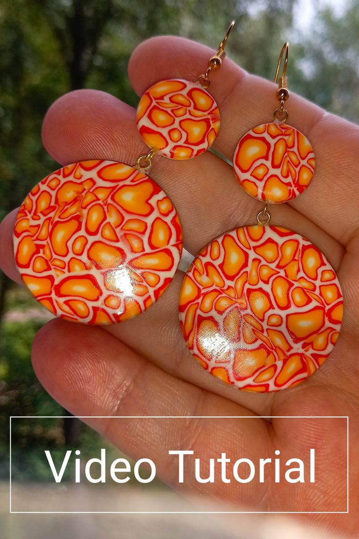 a hand holding three orange and white earrings in it's palm tree - like setting