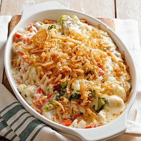 a casserole dish with cheese, broccoli and other vegetables in it