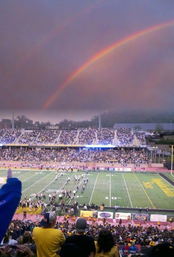 a football stadium filled with people and a rainbow