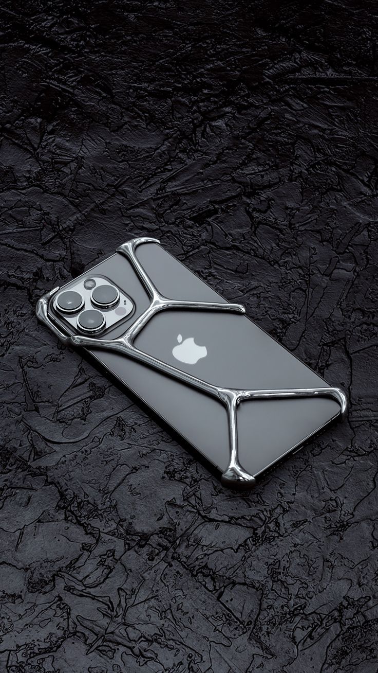 an apple iphone is sitting on top of a black surface with silver metal trims