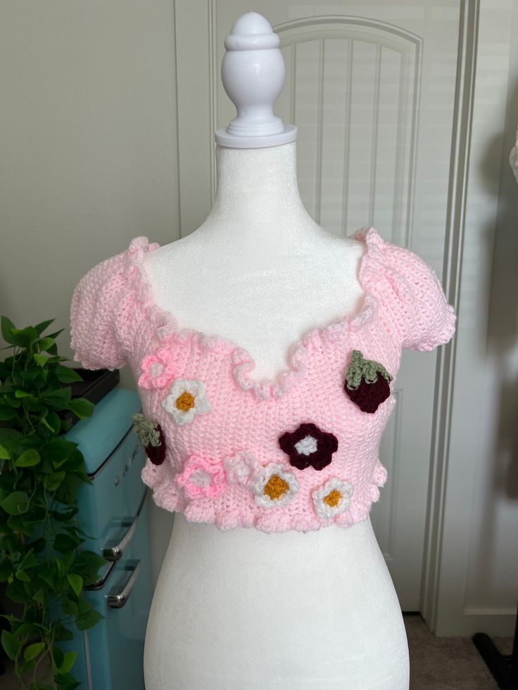 Strawberry Daisy Top🍓🌸  💖original design💖 crocheted by me<3 sizing and characteristics: - size ranges from small to medium - lettuce-trim ruffles - puffy sleeved - adjustable ribbon crossed in back of shirt - flower and strawberry designs attached to front - hand wash and lay flat to dry - shipping cost included in price Sweet Fitted Tops For Summer, Fitted V-neck Pink Crochet Top, Sweet Fitted Tops For Spring, Fitted Crochet Top With Ruffles For Spring, Fitted Crochet Trim Top For Spring, Fitted Crochet Top With Crochet Trim For Spring, Pink Ruffled Tops For Garden Party, Pink Ruffle Top For Garden Party, Casual Spring Crochet Top With Ruffles