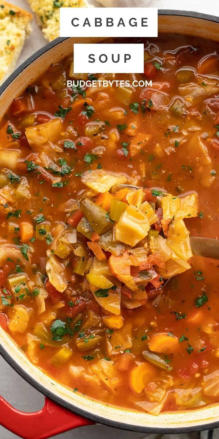 cabbage soup in a red pot with a wooden spoon and bread on the side text reads cabbage soup