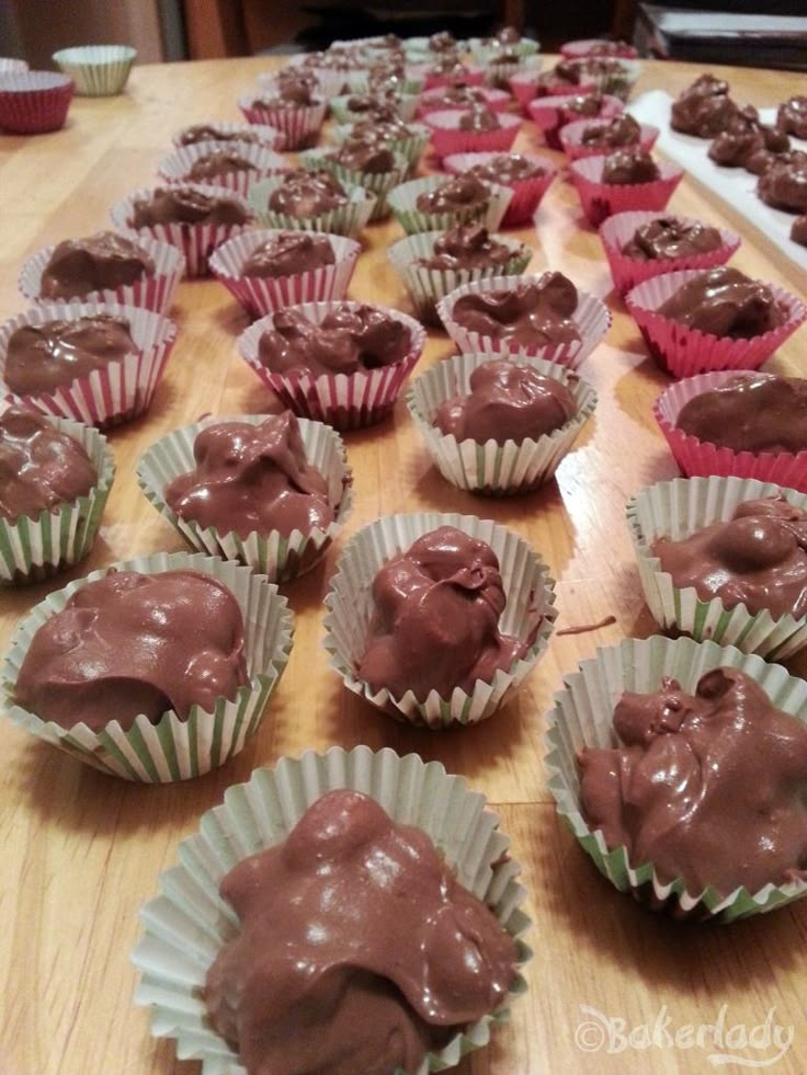 there are many cupcakes with chocolate frosting in them on the table and ready to be eaten