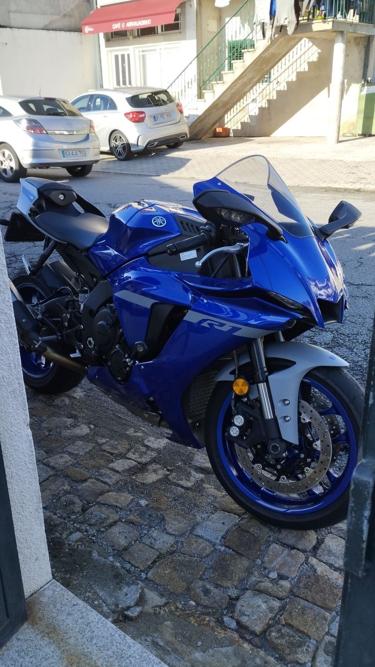 a blue motorcycle is parked on the sidewalk