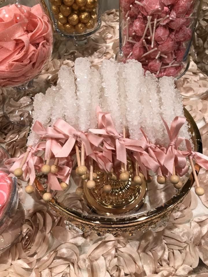 a table topped with lots of pink and gold candies next to other candy items