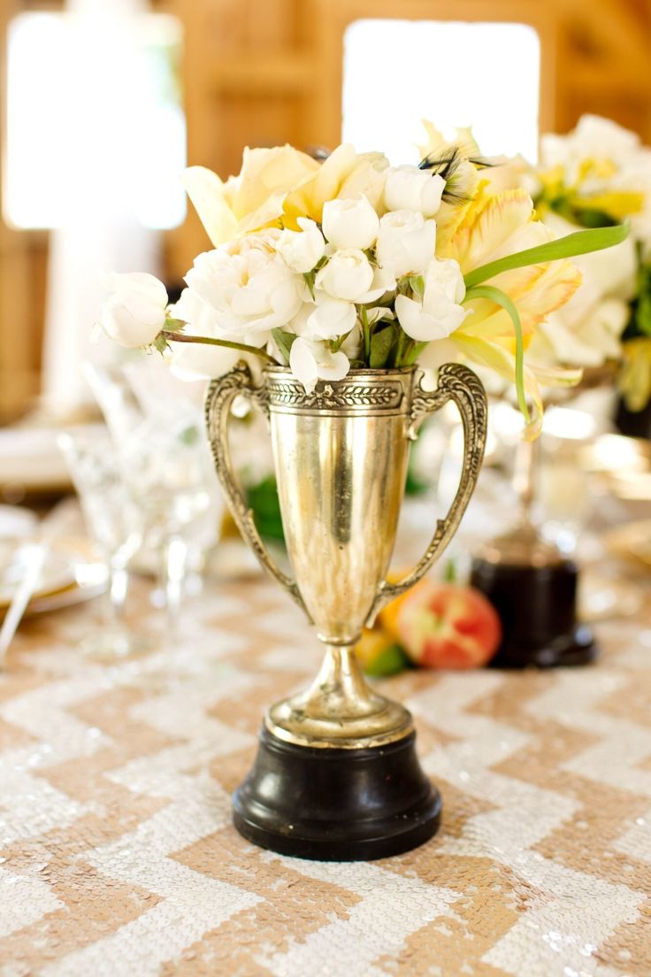 there is a vase with flowers in it on top of the dining room table at this wedding reception