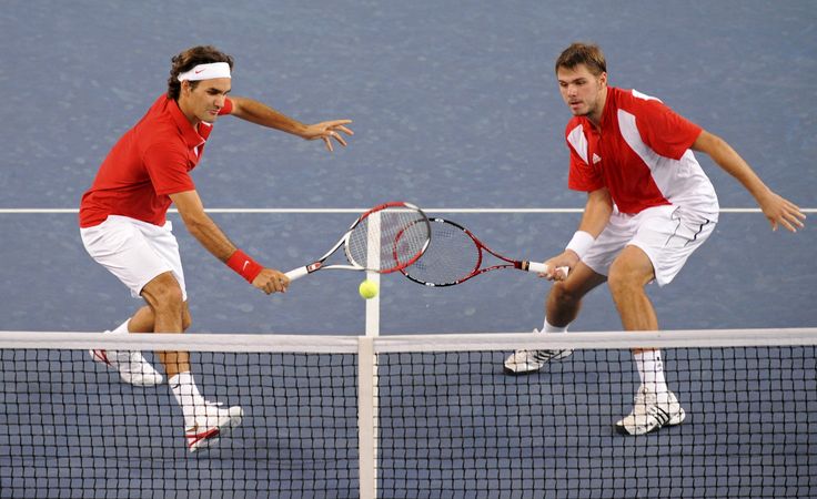 two men are playing tennis on the court