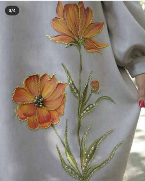 the woman is walking down the street with her hand on her hip and wearing a gray dress with orange flowers