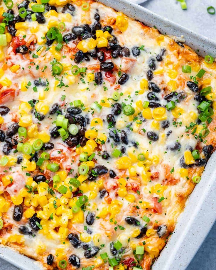 an enchilada casserole with black olives, corn and green onions